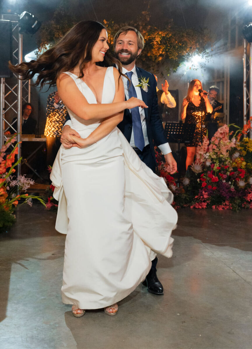 A pair of newlyweds take a spin on the dance floor inside the reception space of their Tuscan wedding.
