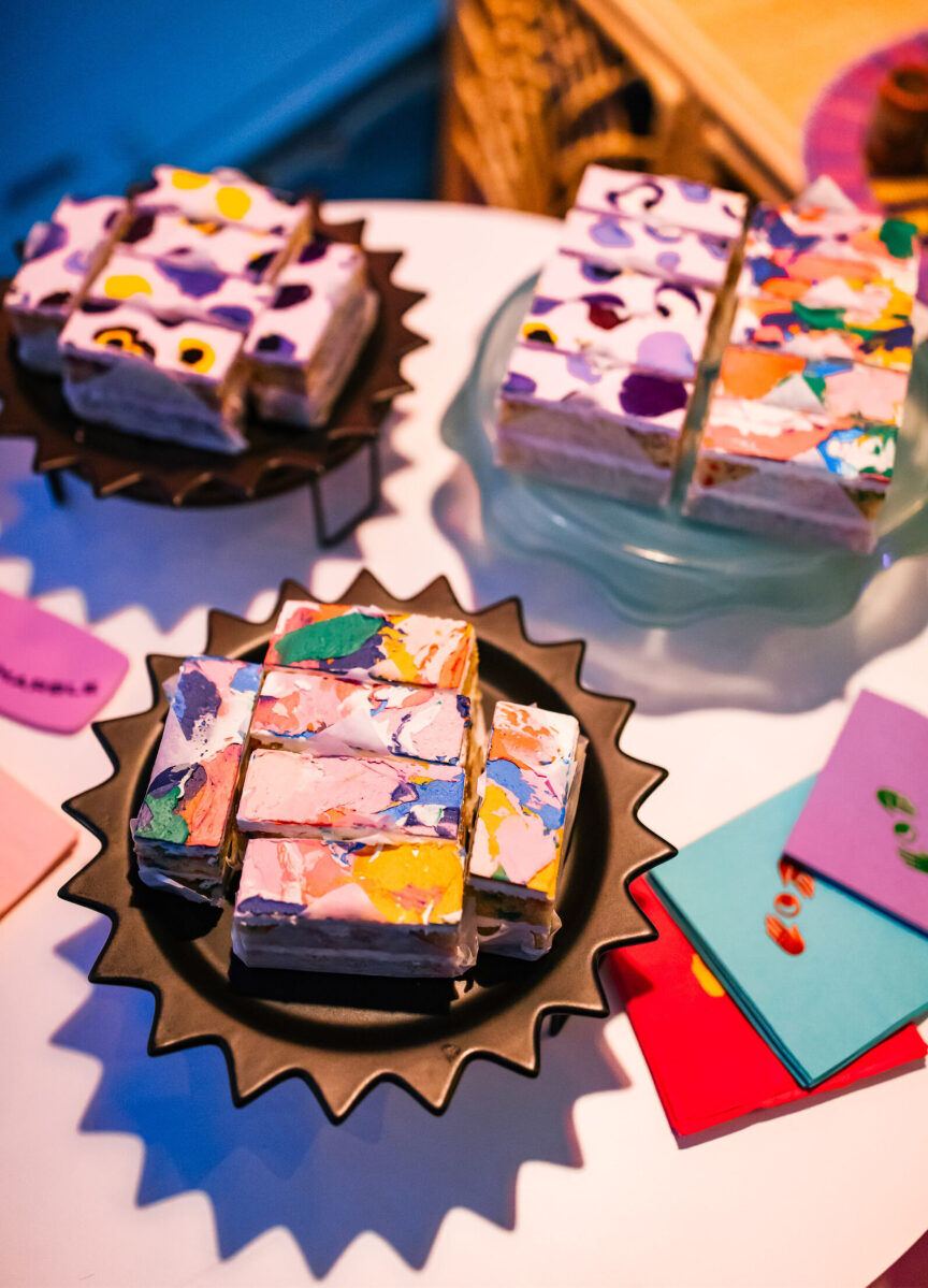 Individually sliced, and colorfully decorated, cake bars were served at a vibrant outdoor wedding.