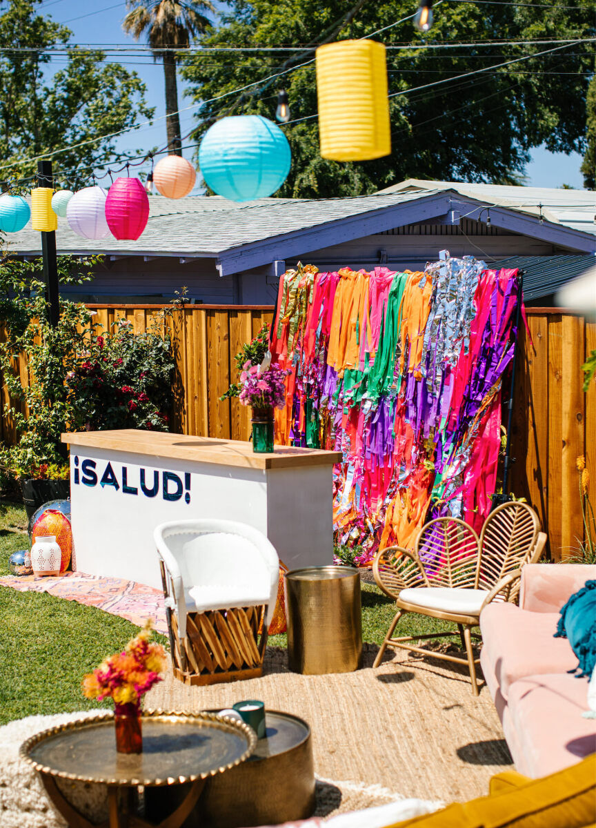 Tissue streamers, fun signage, and hanging paper lanterns were a few ways this vibrant, outdoor wedding felt festive and highly personalized.