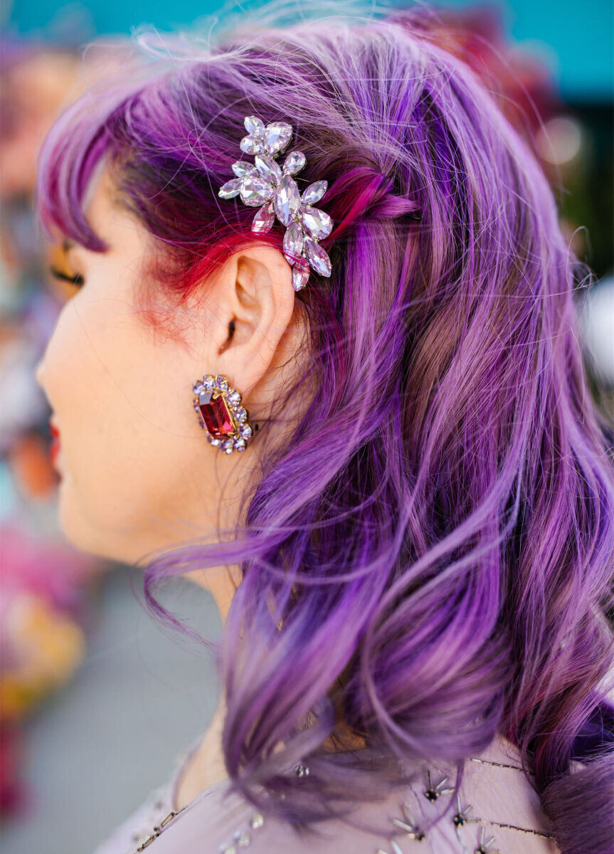 The bride's purple hair was styled in soft waves and pulled behind her ear with a crystal clip.