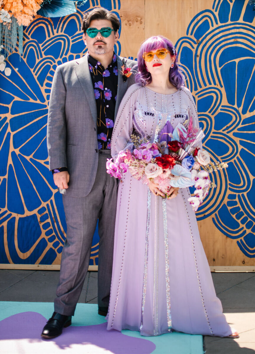 The groom and bride both wore shades of purple (and fun sunglasses) at their vibrant outdoor wedding, which incorporated a slew of color through its folk art meets pop art aesthetic.