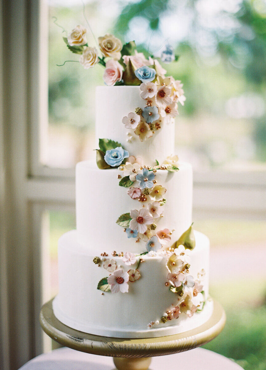 Wedding cake bakery: White minimal wedding cake with tiers and flowers climbing up the side. 