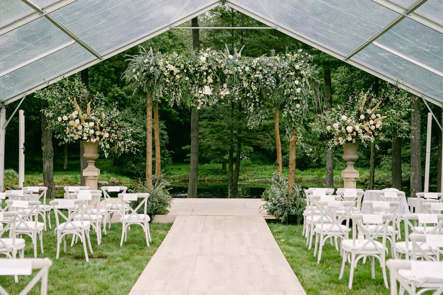 Wedding details: A flower-covered chuppah set up under a clear tent for a Jewish wedding ceremony.