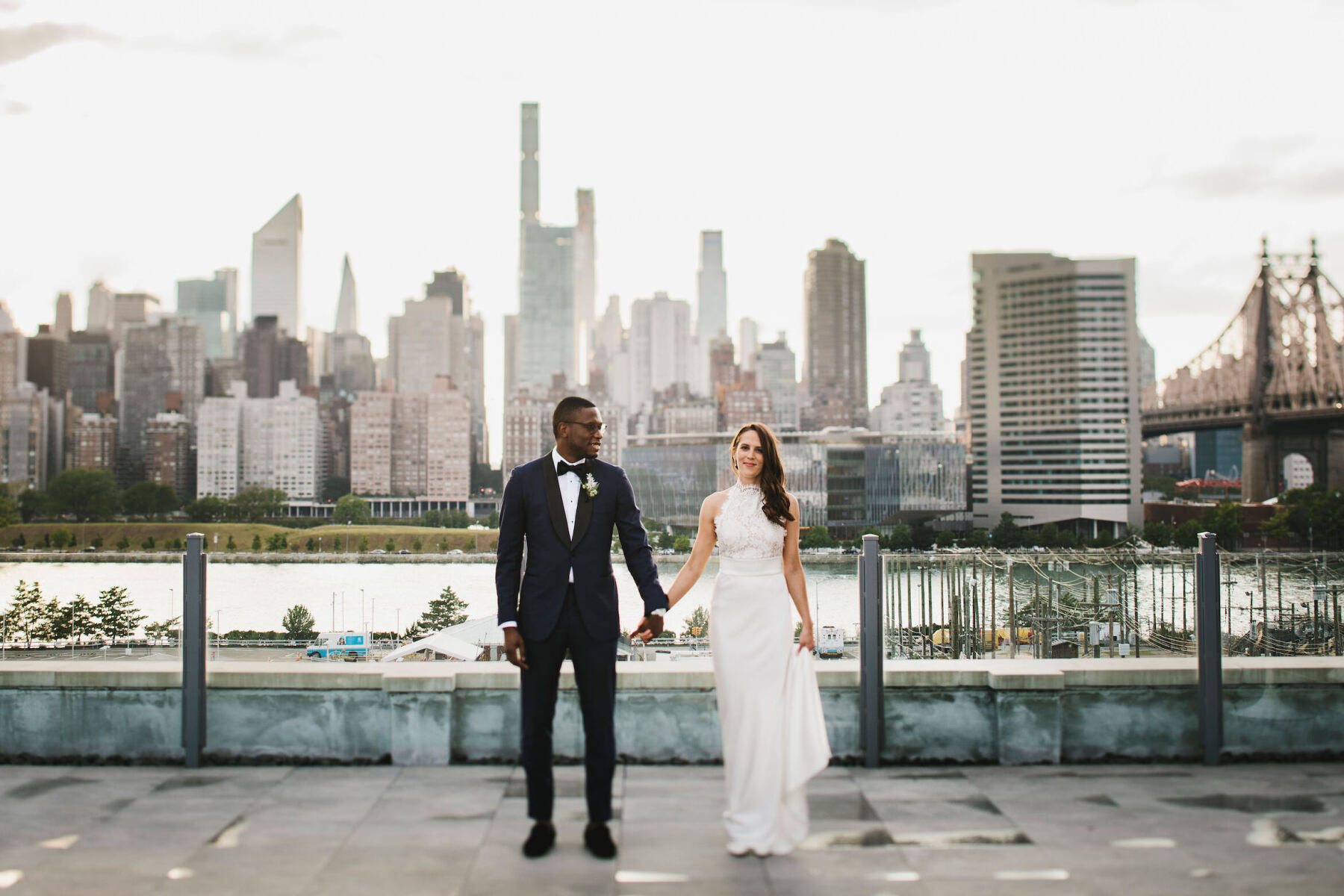 Wedding Dress Shopping: A wedding couple holding hands with a full view of Manhattan behind them.