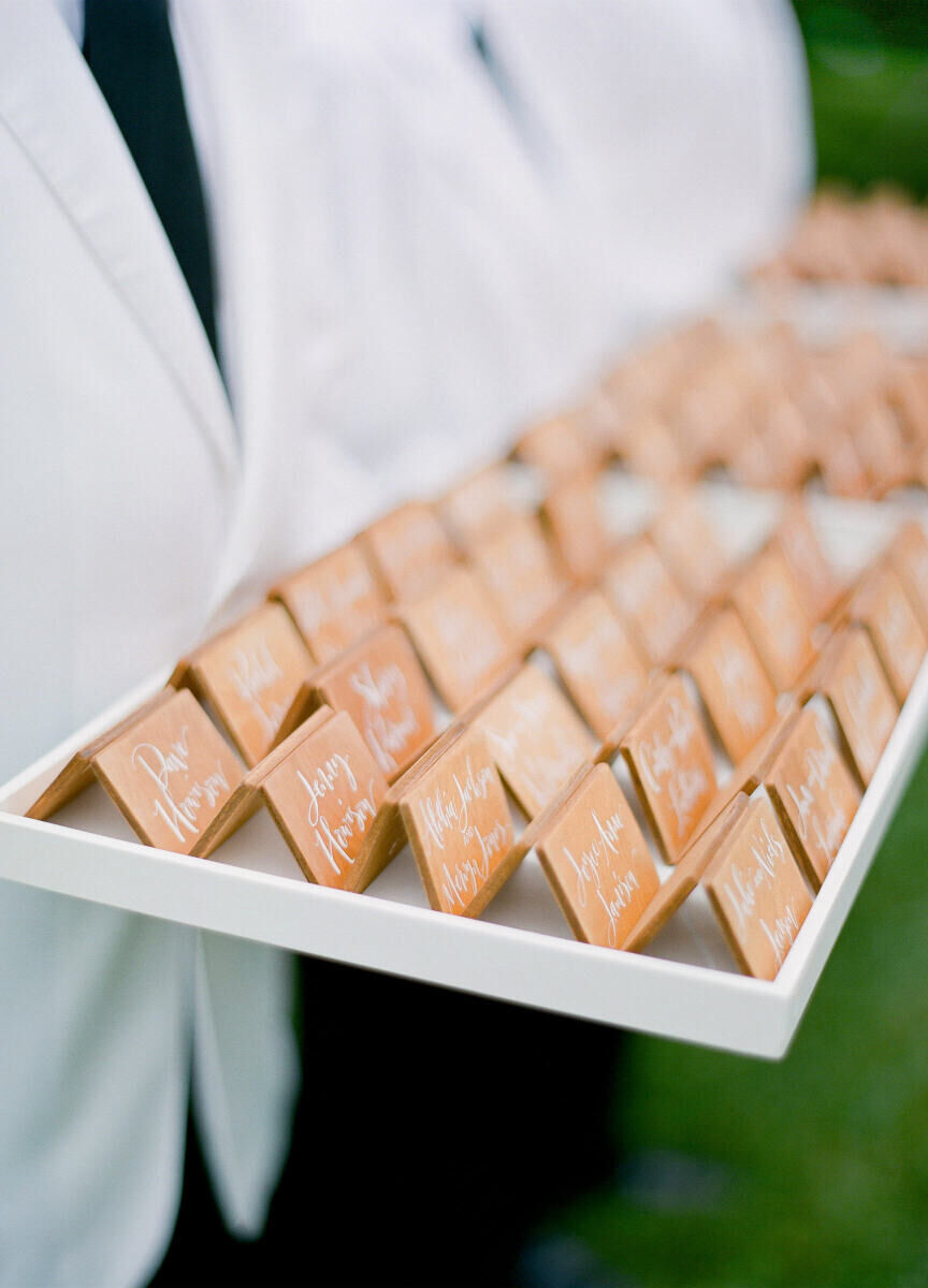 Wedding Etiquette Budget: Wait staff in white coats holding guests' escort cards at cocktail hour. 