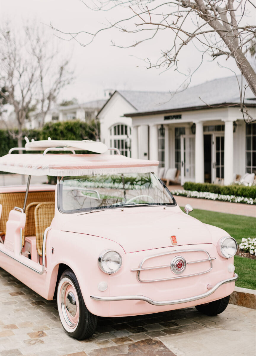 Wedding Etiquette: A light pink golf cart with woven seats parked outside a hotel. 