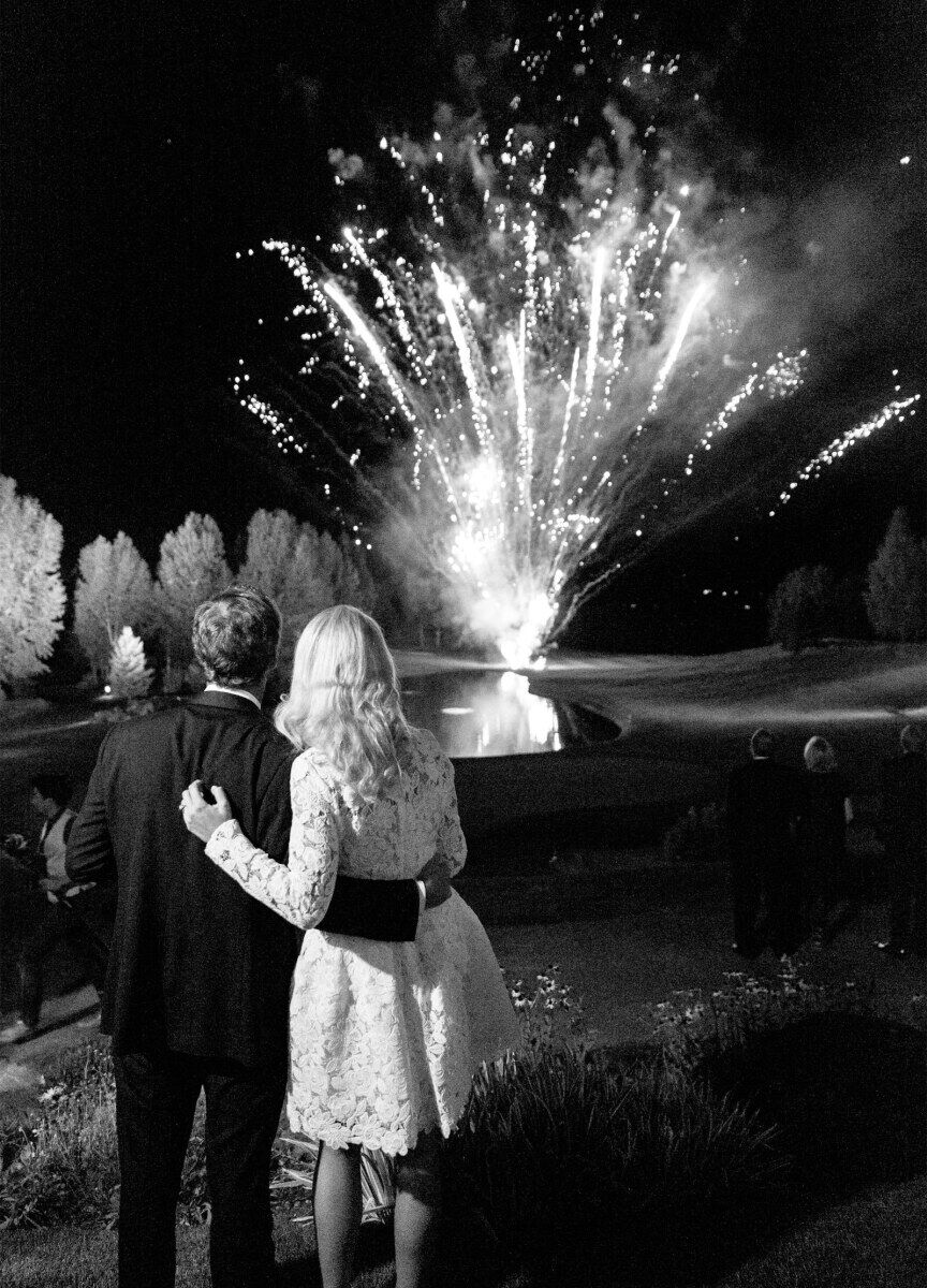 Wedding Fireworks Wedding Sparklers: A wedding couple embracing while looking at a firework display.
