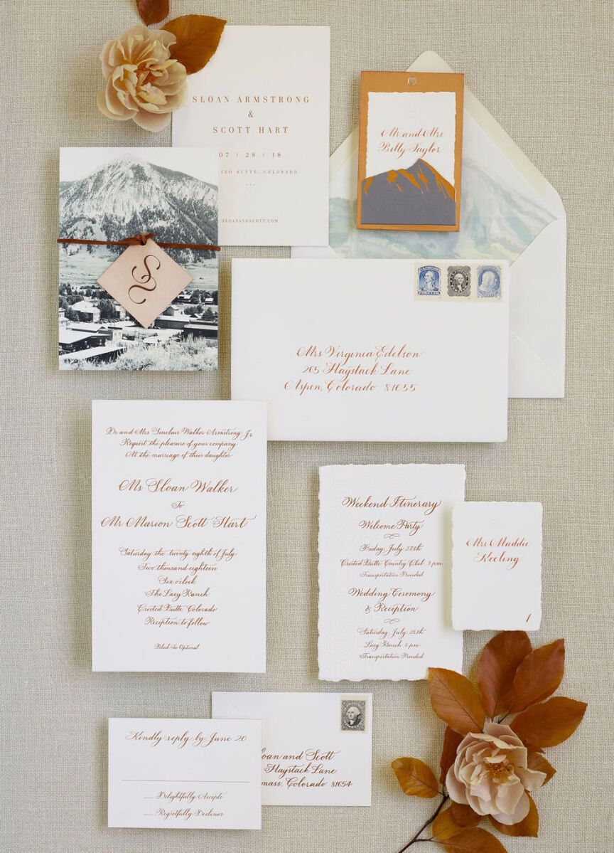 Wedding invitation designer: White wedding invitation designs with red lettering, featuring a mountain illustration and wedding crest 