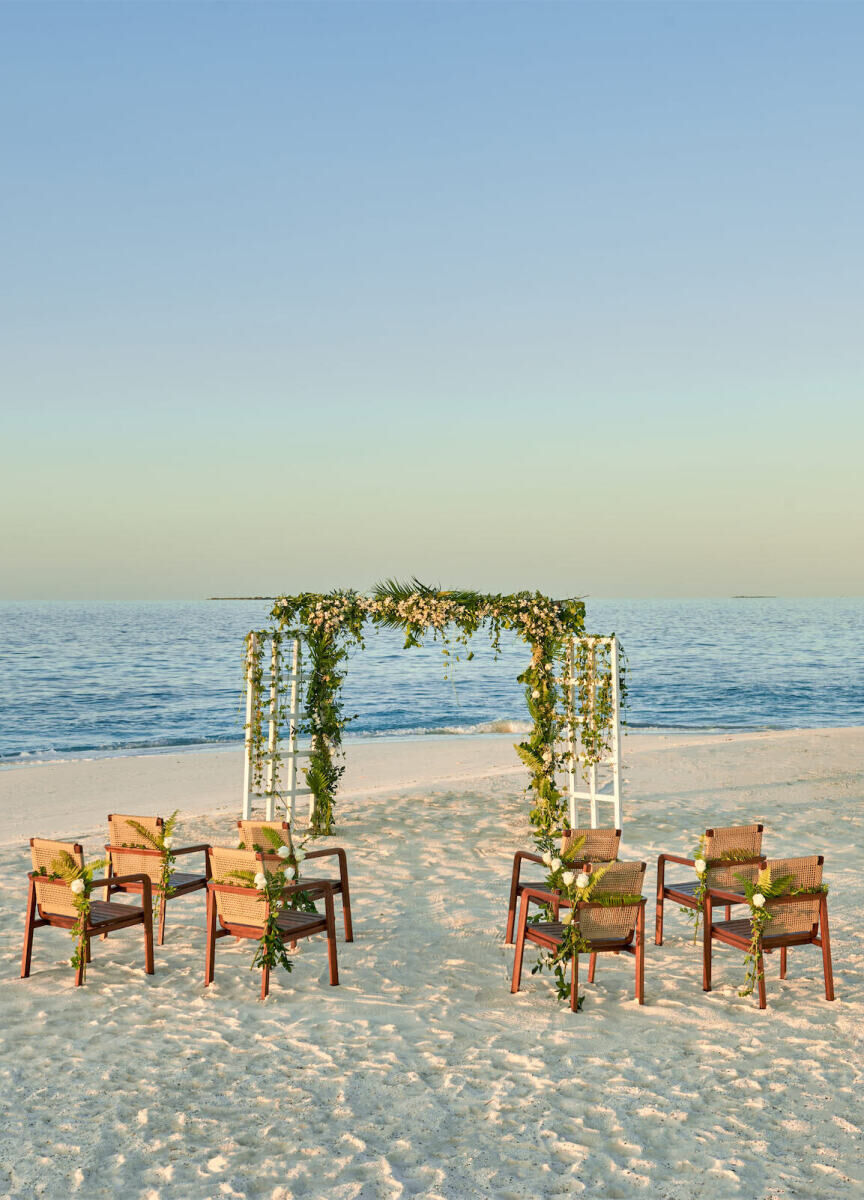 Wedding News: A small beach ceremony set-up with chairs and an arch at Alila Kothaifaru Maldives.