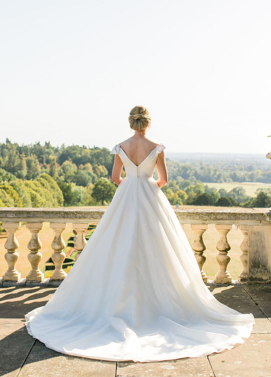 Wedding Photography Ideas: A bride looking out on a balcony at a wedding venue in the UK.