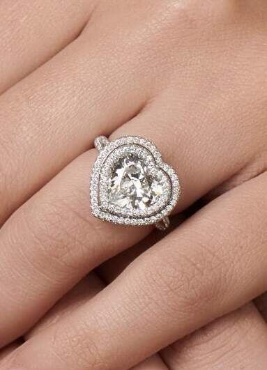 Wedding Ring Design: A heart cut engagement ring with a double halo on someone's finger.