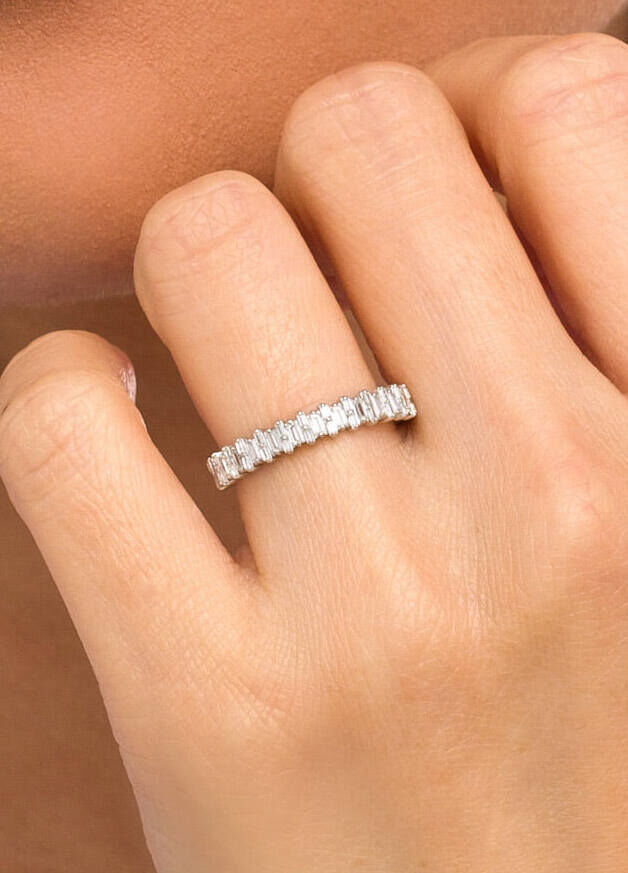 Wedding Ring Design: A baguette diamond wedding ring band on a ring finger.