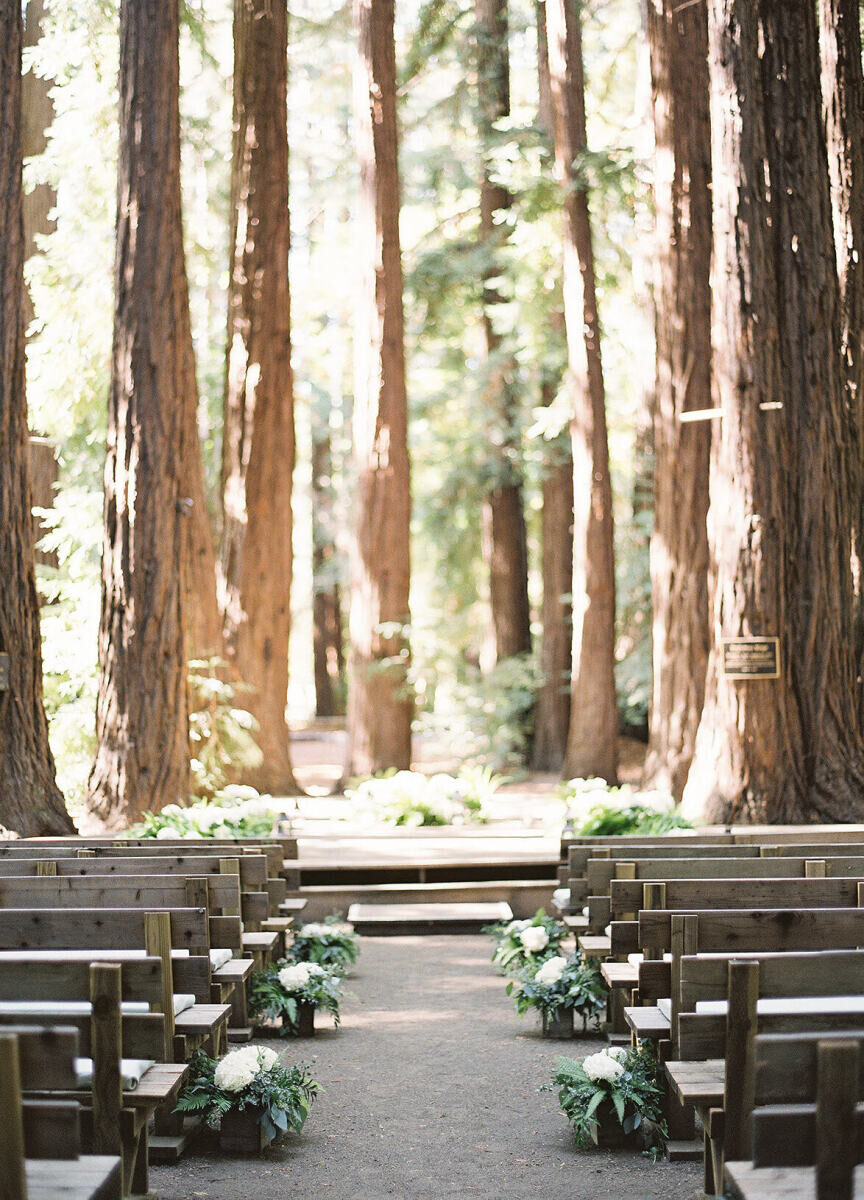 Wedding Tips: An outdoor forrest ceremony set-up with simple white flowers lining the aisle and wooden bench seats.