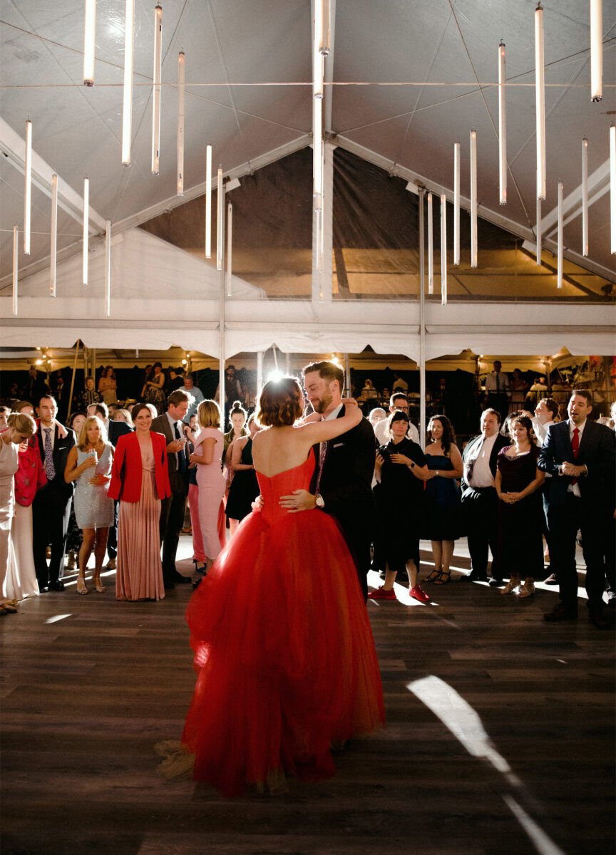 Wedding Tips: Newlyweds dancing under a hanging light installation while guests stand around them.
