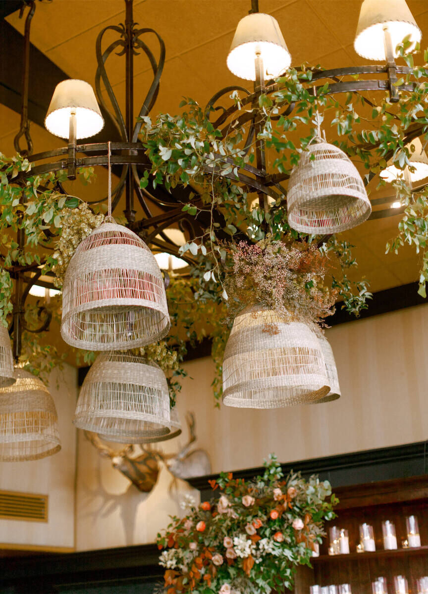 Wedding Tips: Light installations and wicker features hanging from the ceiling in a reception space.