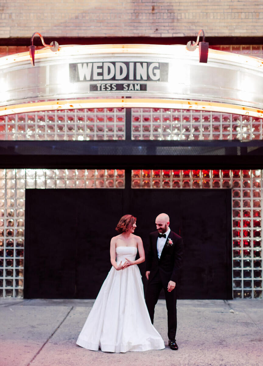 Best Wedding Venues for Creative Couples: A bride and groom standing outside the Williamsburg Hall of Music, which has their names (Tess and Sam) on the marquee with the word 