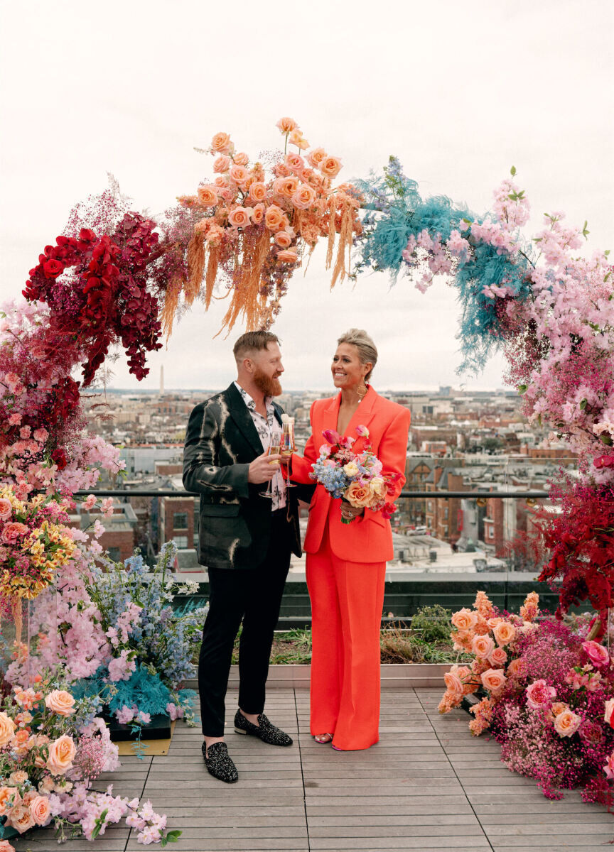 Best Wedding Venues for Creative Couples: A couple on the roof of The Line DC under a colorful floral installation.