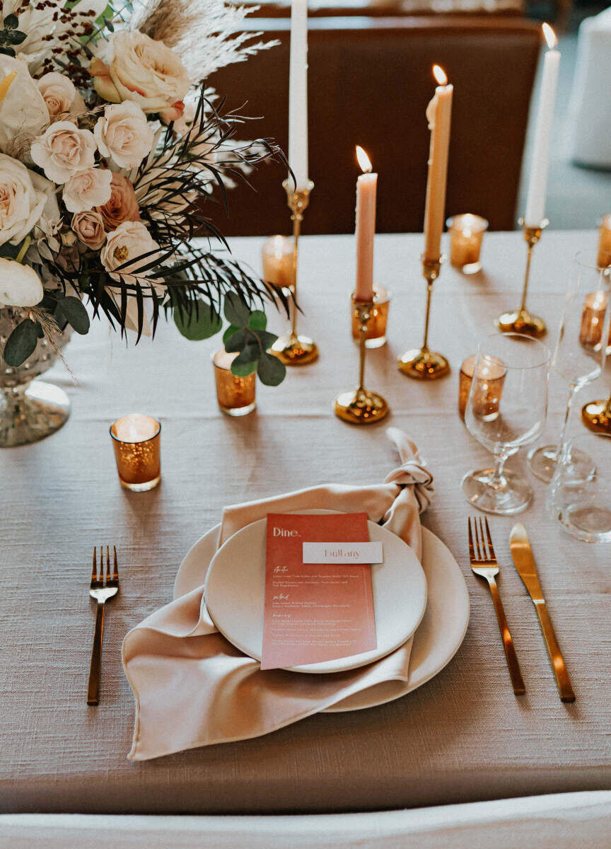 Wedding Website Examples: A pink and orange tablescape at a wedding reception.