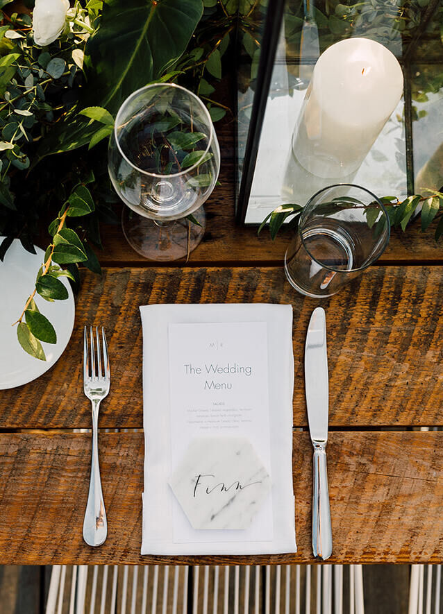 Wedding Website Examples: A bird's eye view of a reception table setting on a wooden table.