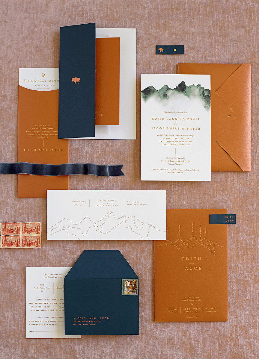 Wedding Website Examples: A flat lay of chestnut and navy wedding invitations and stationery.