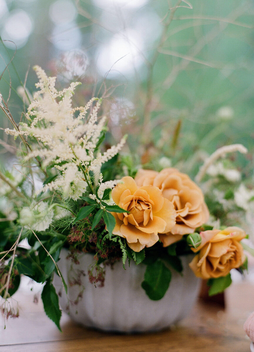 Wedding Website Examples: A reception bouquet with marigold-colored and white florals.
