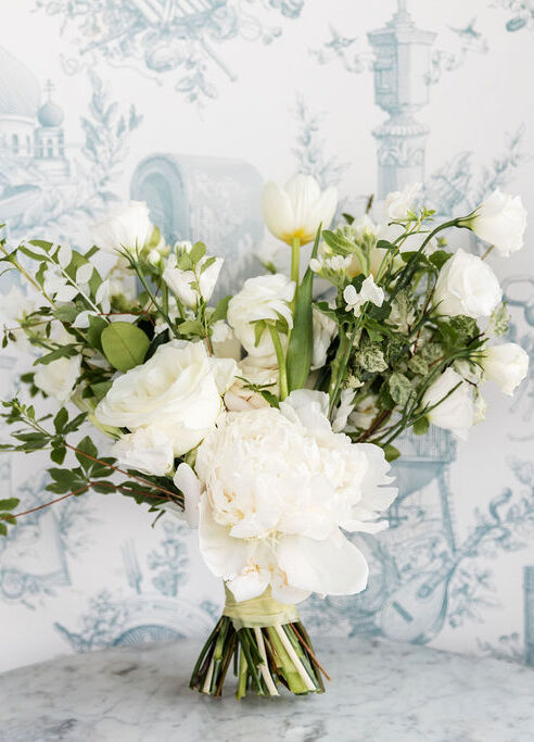 Wedding Website Examples: A wedding bouquet with white florals and green stems.