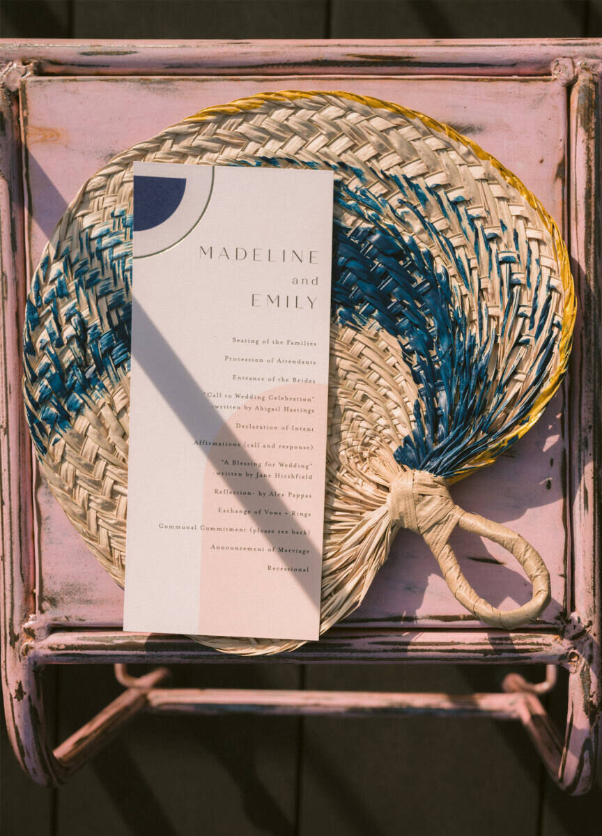 Wedding Website Examples: A flat lay showing a woven fan and piece of wedding stationery.