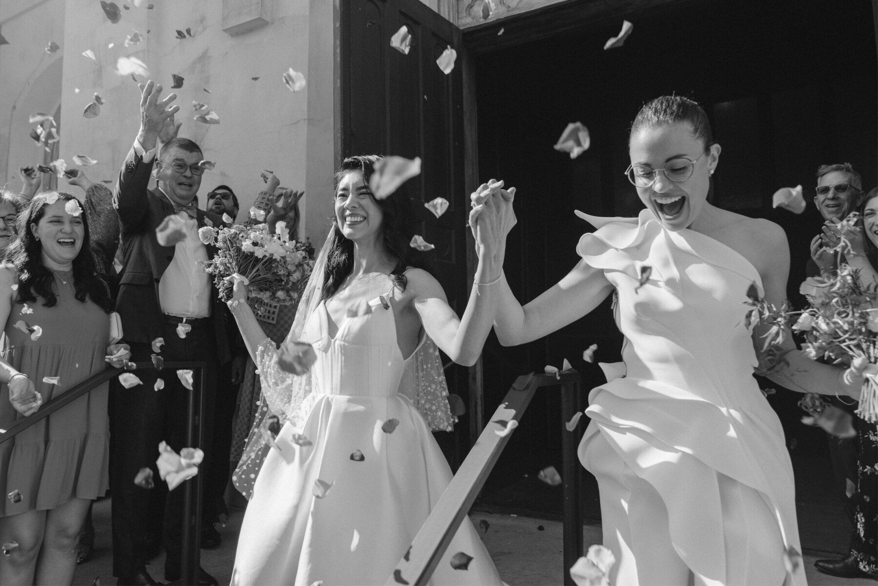 Brides exit their ceremony venue—a former church—at their whimsical wedding in New Orleans.