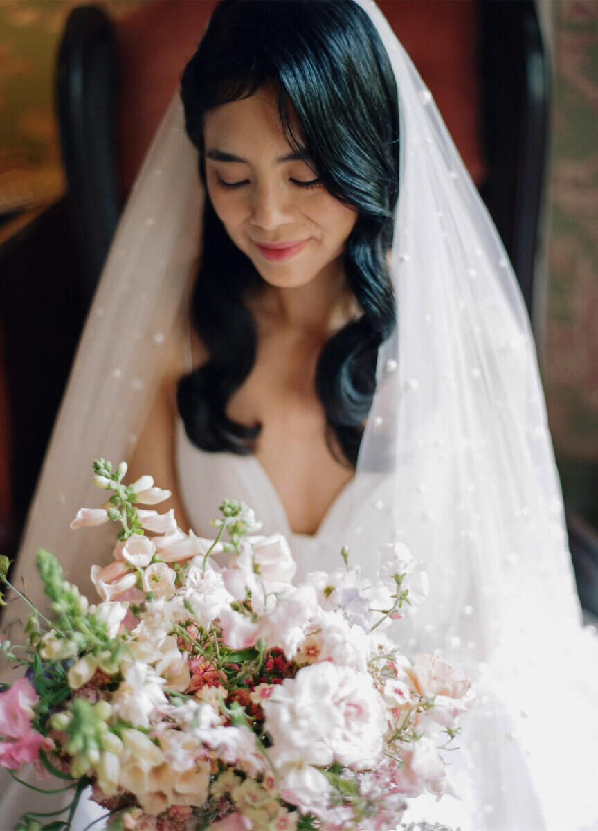 Soft finger waves were requested by a bride who wore a pearl-adorned veil at her whimsical wedding.