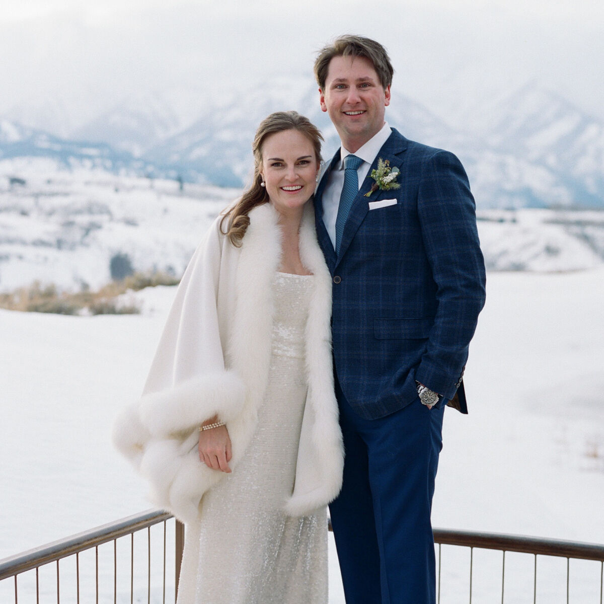 Winter wedding details: A couple pose in front of the mountains at their winter micro wedding at Amangani in Jackson, Wyoming