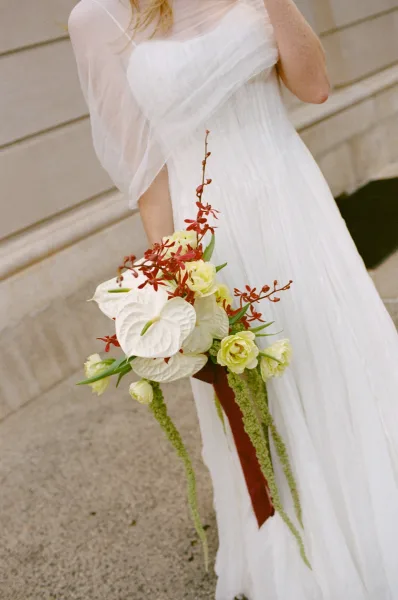 Bridal bouquet, a white anthurium bouquet with trailing amaranthus and textural greens, styled in a modern, asymmetrical shape.