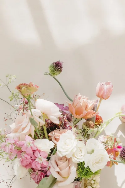 Floral centerpiece, a garden style centerpiece with lush roses layered in a full, natural composition, showcasing soft curves and depth