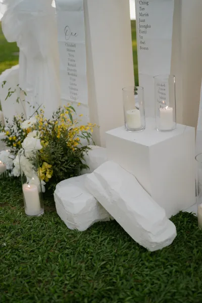 Wedding seating chart presented as a scroll seating chart on a fabric banner, flanked by glowing candles for an elegant, minimalist display.