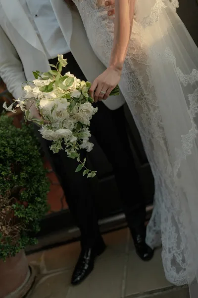 Bridal bouquet featuring a cascading bridal bouquet design with organic, asymmetrical lines, cradled against a lace veil.