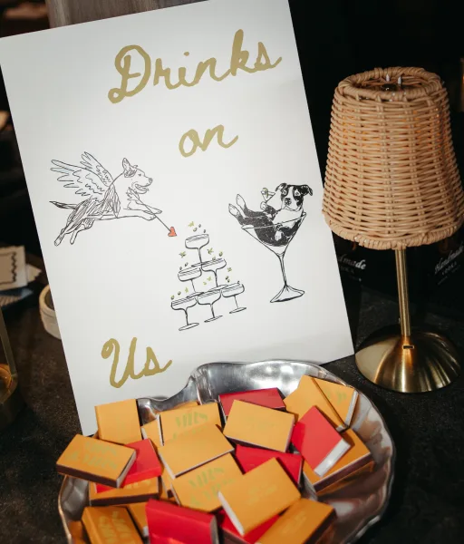 Wedding bar sign, an open bar sign in gold lettering, set against a dark backdrop atop a bar counter.