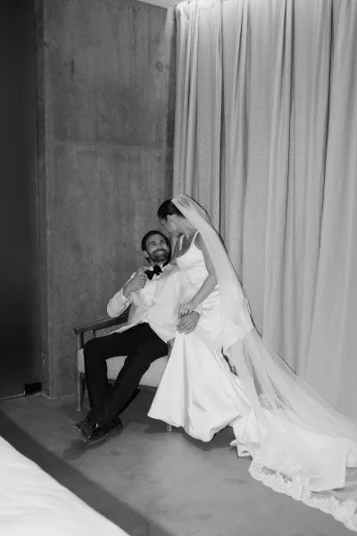Couple portrait of a bride leaning on groom, her long veil flowing as they pose serenely, highlighting their classic, elegant wedding style.