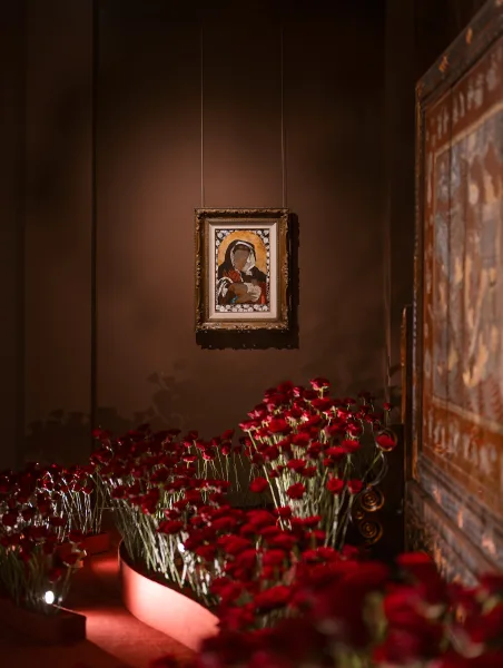 Ceremony aisle decor with red rose aisle flower boxes and candles leading up steps, set against a brown wall with framed artwork