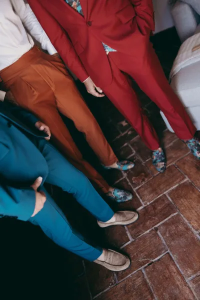 Men's wedding suits styled as colorful wedding suits, with a floral shirt accent adding flair to a bold, modern groomsmen look.