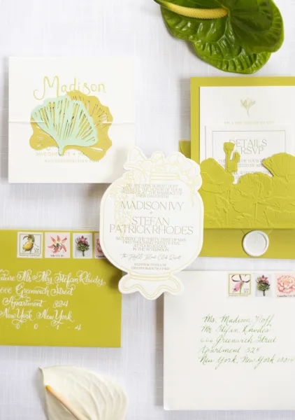 Wedding invitation suite with botanical wedding invitations, die-cut leaf cards, wax seal and vintage stamps on white linen flat lay