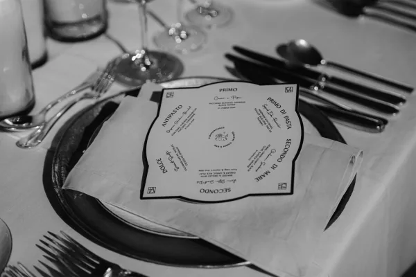 Wedding menu presented as a die-cut menu card, centered on a charger plate for an elegant place setting.