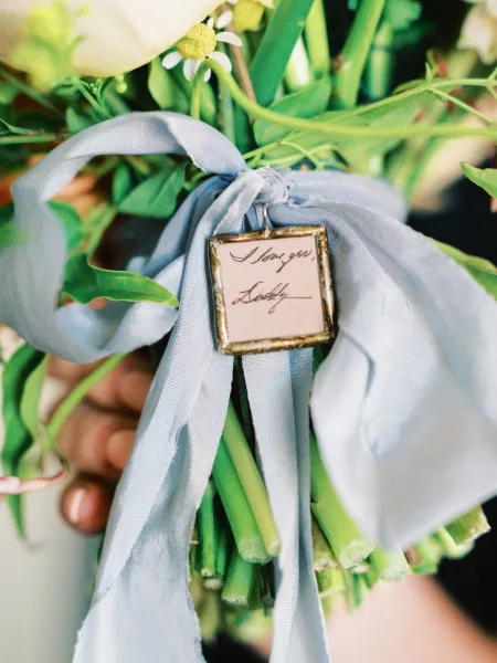 Bouquet charm highlighting a memorial bouquet charm tied with a blue silk ribbon, a tender keepsake detail to honor a loved one.
