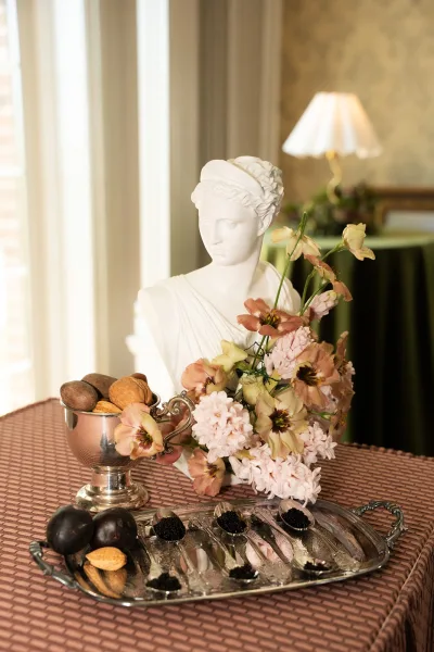 Wedding food display with a caviar bar wedding spread, elegantly arranged beside a classical statue bust.