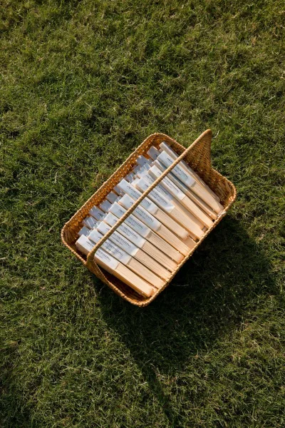 Wedding fans arranged as hand fan favors in a wicker basket for guests, neatly stacked and ready to keep everyone cool.
