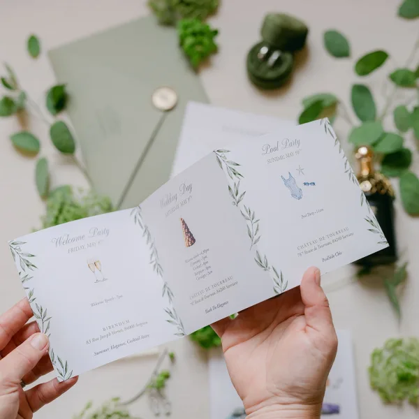 Invitation suite featuring a tri fold wedding invitation, styled with a wax seal on a light tabletop.