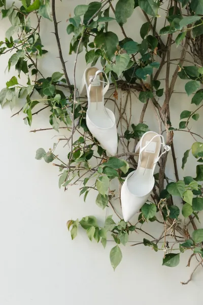Bridal shoes, white slingback wedding shoes displayed neatly with delicate vines entwined around the straps, creating a simple, elegant detail.