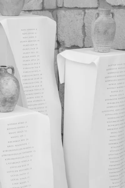 Wedding seating chart presented as a fabric seating chart, neatly displayed against a textured stone wall.