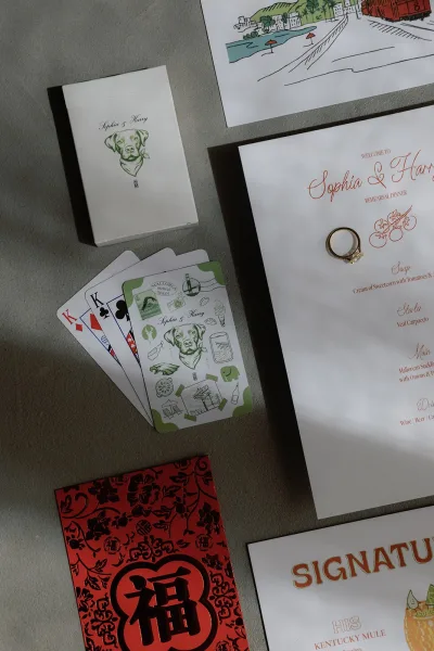 Wedding stationery featuring an illustrated wedding menu and a red envelope, artfully arranged with clean, modern lines.