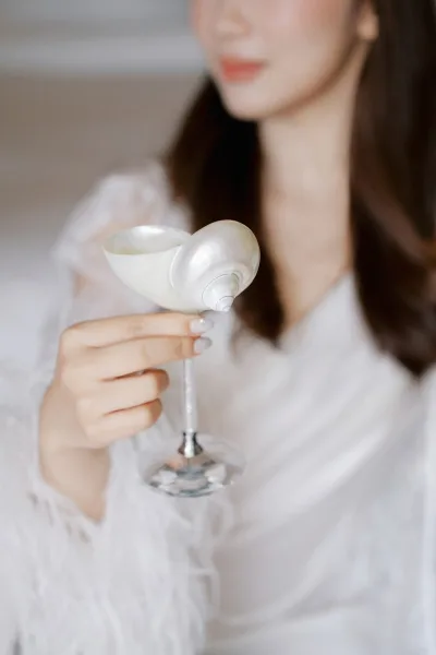 Champagne coupe styled as a seashell champagne glass, elegantly curved with a unique sculptural bowl, ready for a refined celebratory toast.