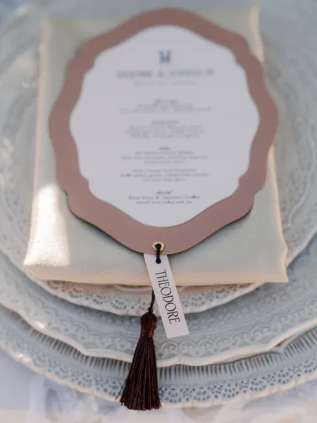 Wedding menu features a tassel menu card presented simply, conveying timeless elegance suited to a formal place setting.
